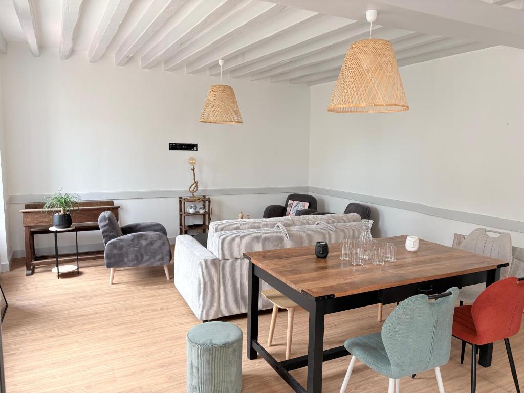 a living room with a couch and a table and chairs at Le calme dans 100M2 in Condé-sur-Sarthe