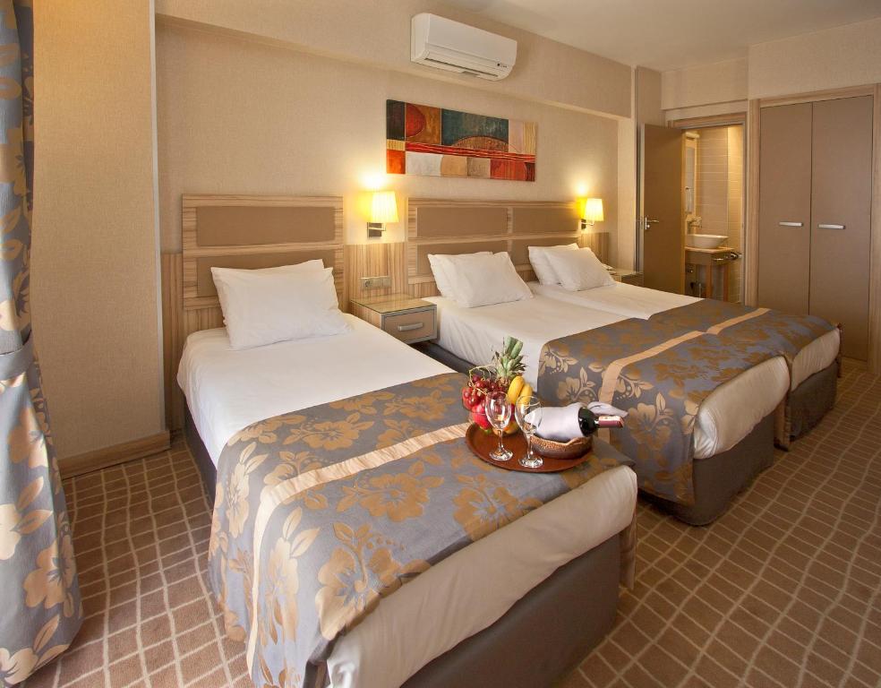 イスタンブールにあるナンダ ホテルのベッド2台とテーブルが備わるホテルルームです。