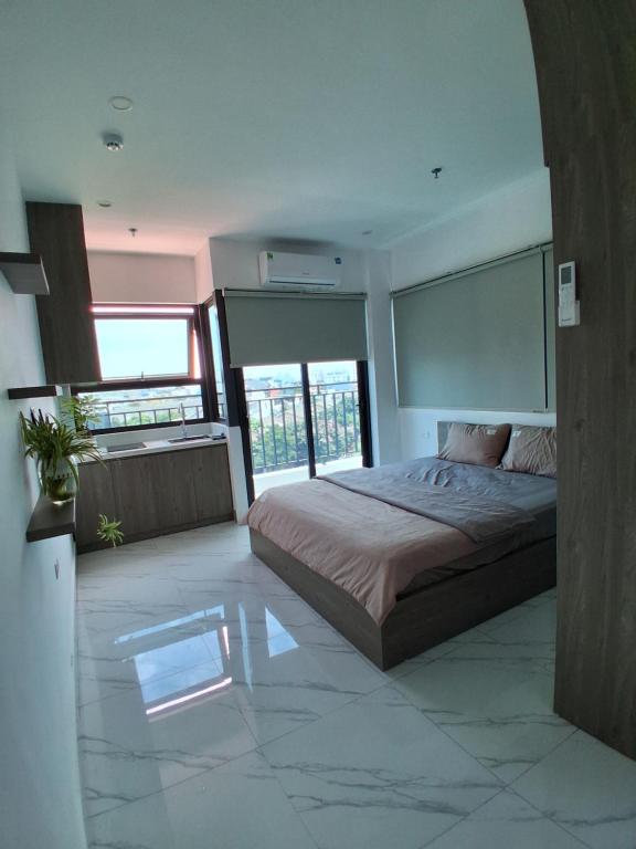 a bedroom with a large bed and some windows at Homestay Vân Canh Hà Nội in Ðại Tự