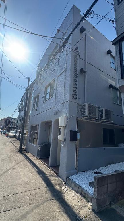 a large white building on the side of a street at attomi hostel 2 in Sapporo