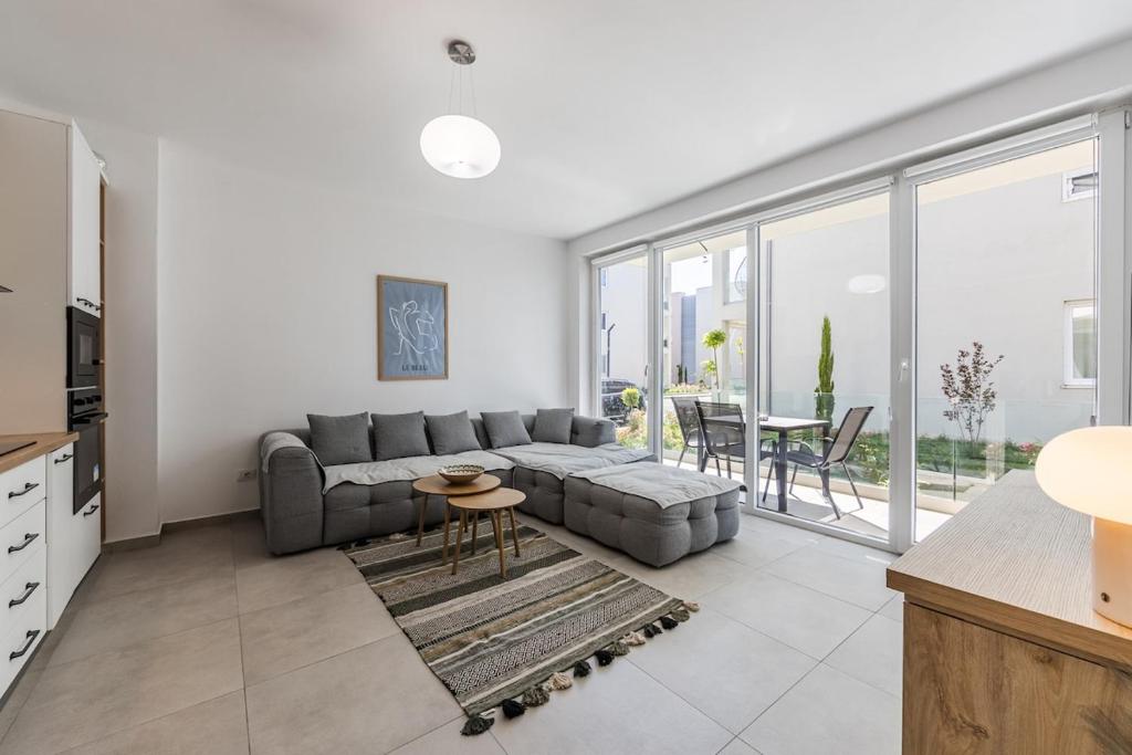 a living room with a couch and a table at Le Bleu Apartment Pool & Beach by PikHost in Lezhë