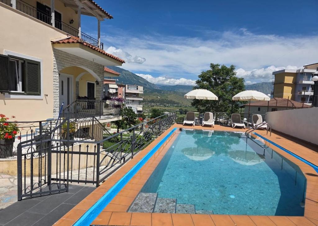 a swimming pool with a view of a house at Family Vacation Home in Gjirokastër
