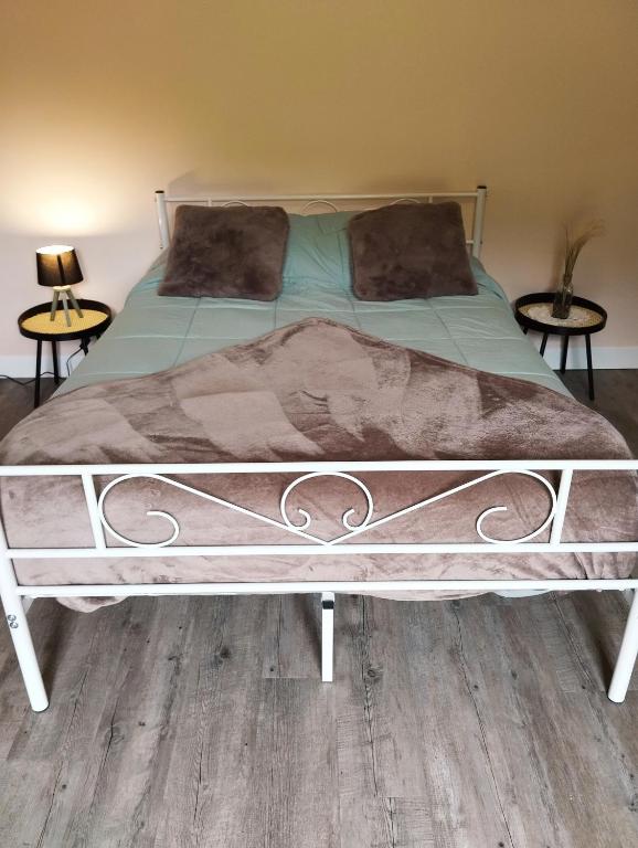 a bed in a bedroom with two end tables at Chez Nanard et Lili in Bec-de-Mortagne