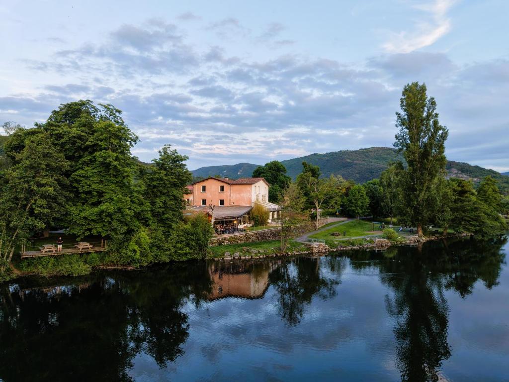 a house sitting on the side of a river at Hotel du Lac & Restaurant Foix in Foix