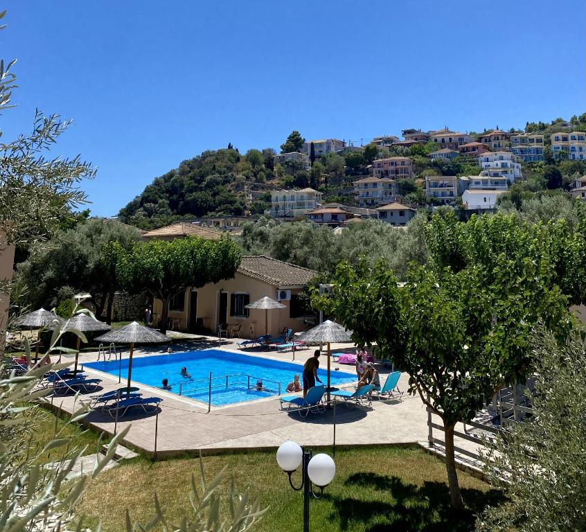 a swimming pool with people sitting in chairs next to it at Rania Studios in Lefkada