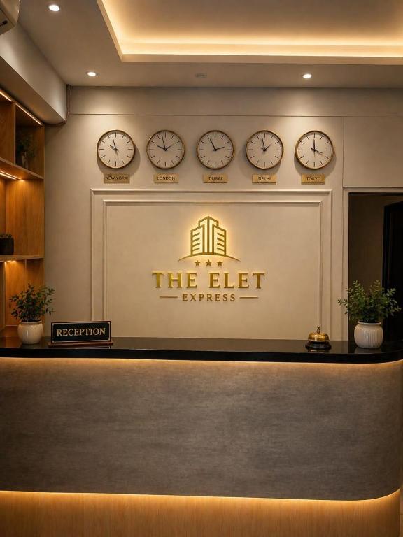 a lobby with four clocks on a wall at The Elet Express Luxury Hotel Apartments in Karachi