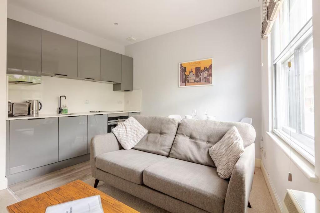 a living room with a couch and a kitchen at Entire 1 Bed Central Flat - St Albans in St. Albans