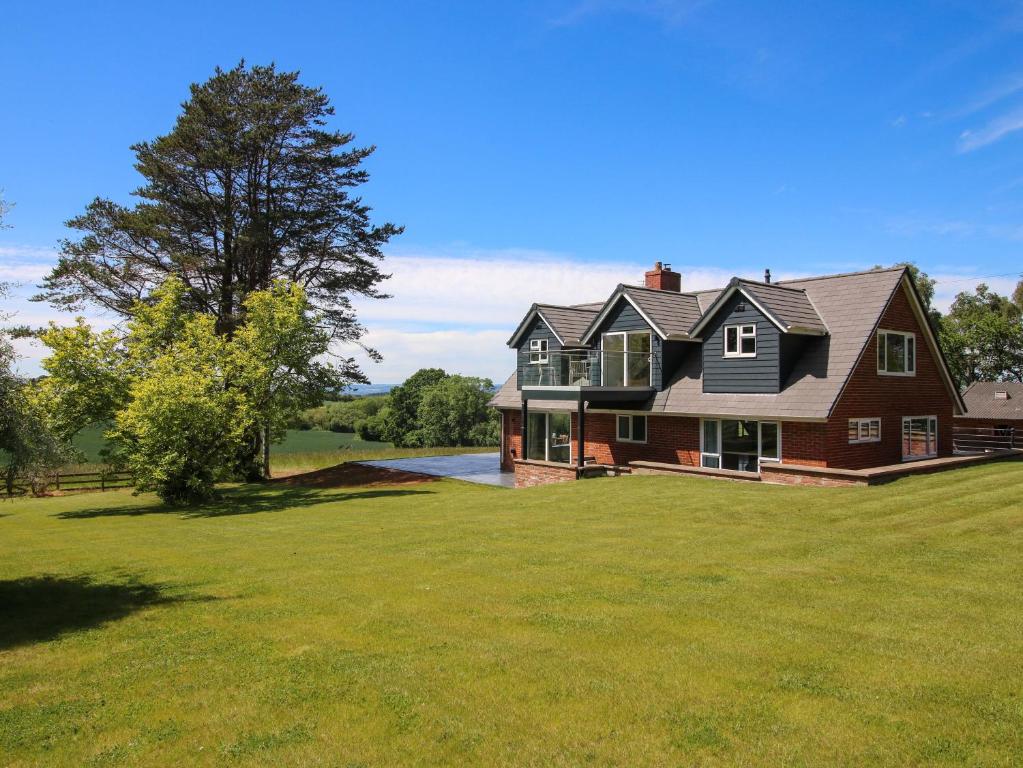 a large red house on a grassy field at Westington Hall in Leominster