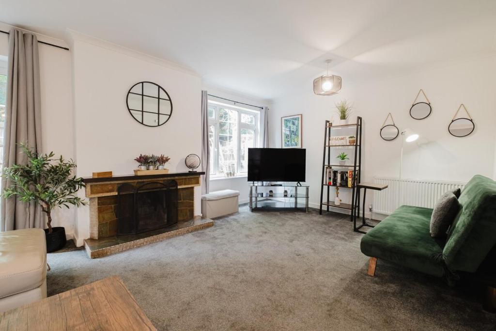 a living room with a fireplace and a television at Spacious 4-Bed Home with Free Parking in Northampton