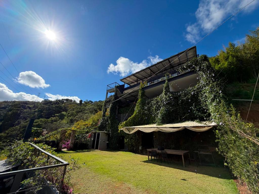 a building with a picnic table and ivy on it at Mirante de itaipava in Itaipava