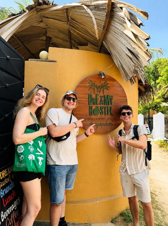 a group of three people standing in front of a building at Dreamy Hostel Arugambay in Arugam Bay