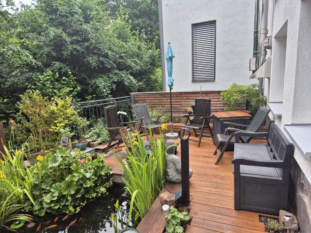 a wooden deck with chairs and plants on a balcony at Ferienwohnung Meise in Sundern