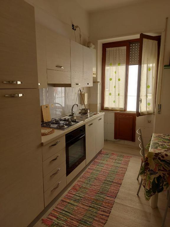 a kitchen with white cabinets and a stove top oven at Mare Blu' in Crotone