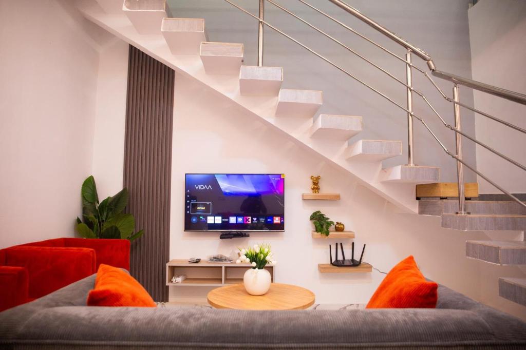 a living room with a couch and a tv at SARALIS Home in Abidjan