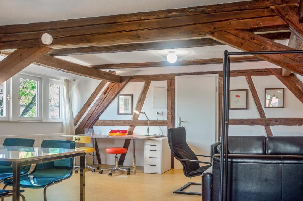 an attic office with a desk and chairs at Alte Schmiede Ellrichshausen 1 in Satteldorf