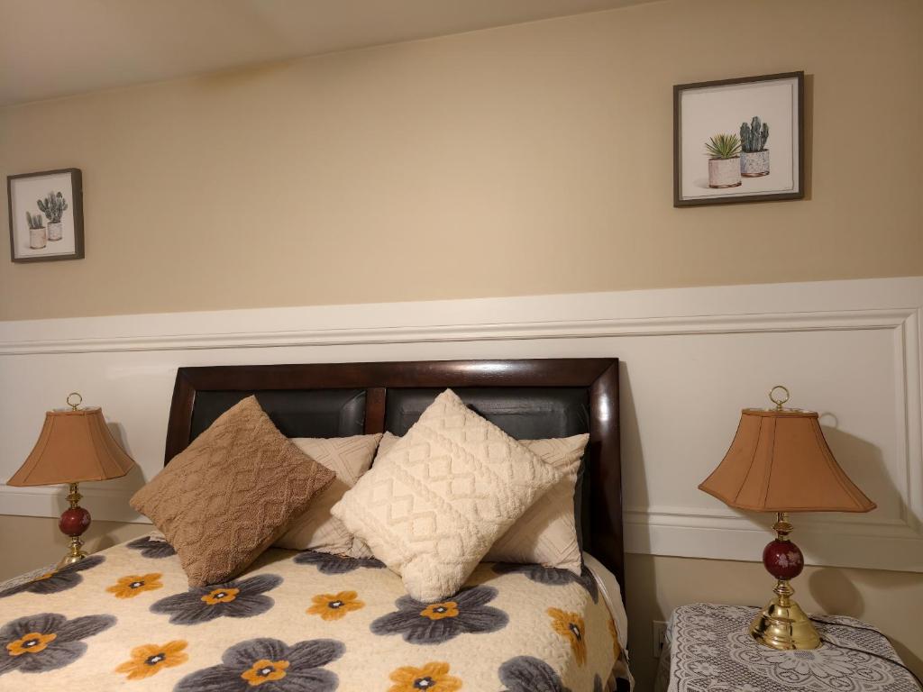 a bedroom with a bed with pillows and two lamps at Near Cavendish Beach-1 in Stanley Bridge