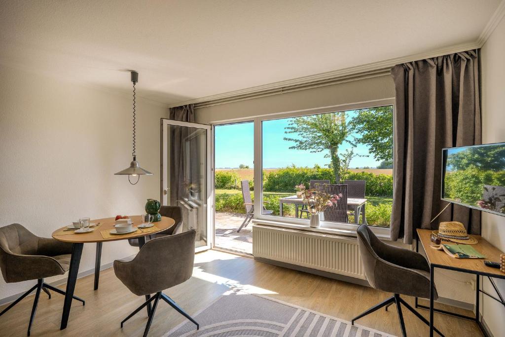 a living room with a table and a large window at Boddenweite 3 in Born