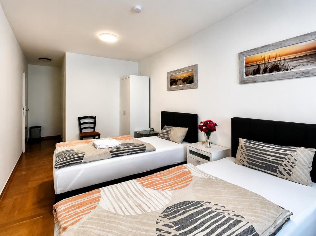 two beds in a room with white walls at Stendaler Apartments in Stendal