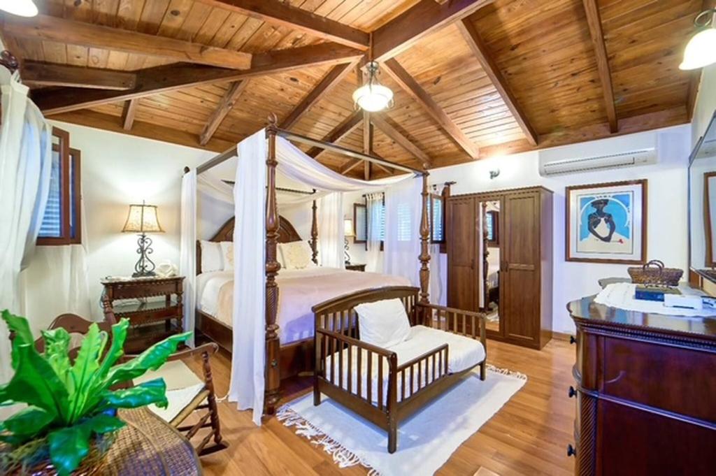 a bedroom with a canopy bed and a wooden ceiling at Las Margaritas, Casa de Campo in La Romana