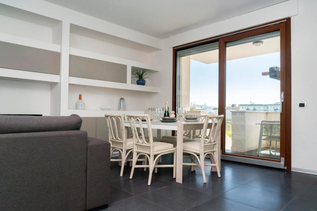 a kitchen and dining room with a table and chairs at Appartamento dell'Aurora by Le Dune Villas in Porto Cesareo