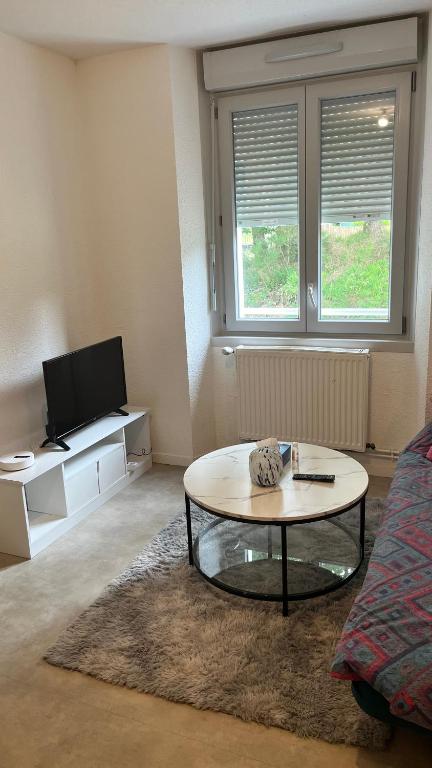 a living room with a coffee table and a tv at Ancrage home in Montargis