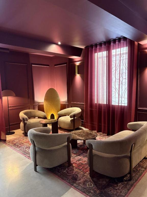 a living room with couches chairs and a table at Hôtel Le Médiéval Palais des Papes in Avignon