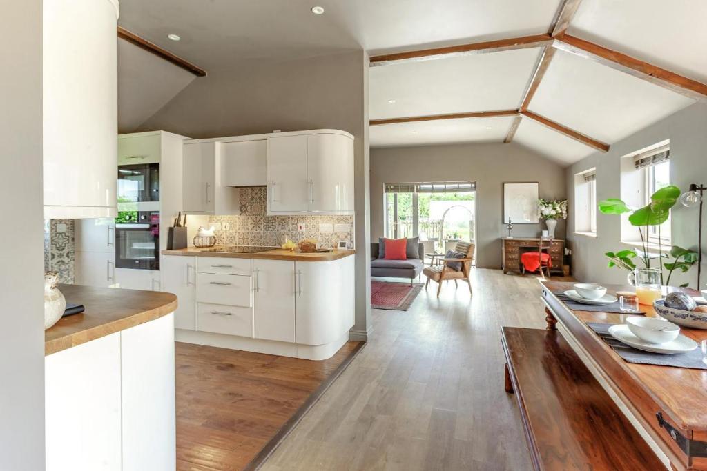 a kitchen and living room with white cabinets and a table at 2 Bed in Devizes oc-t43754 in Bulkington