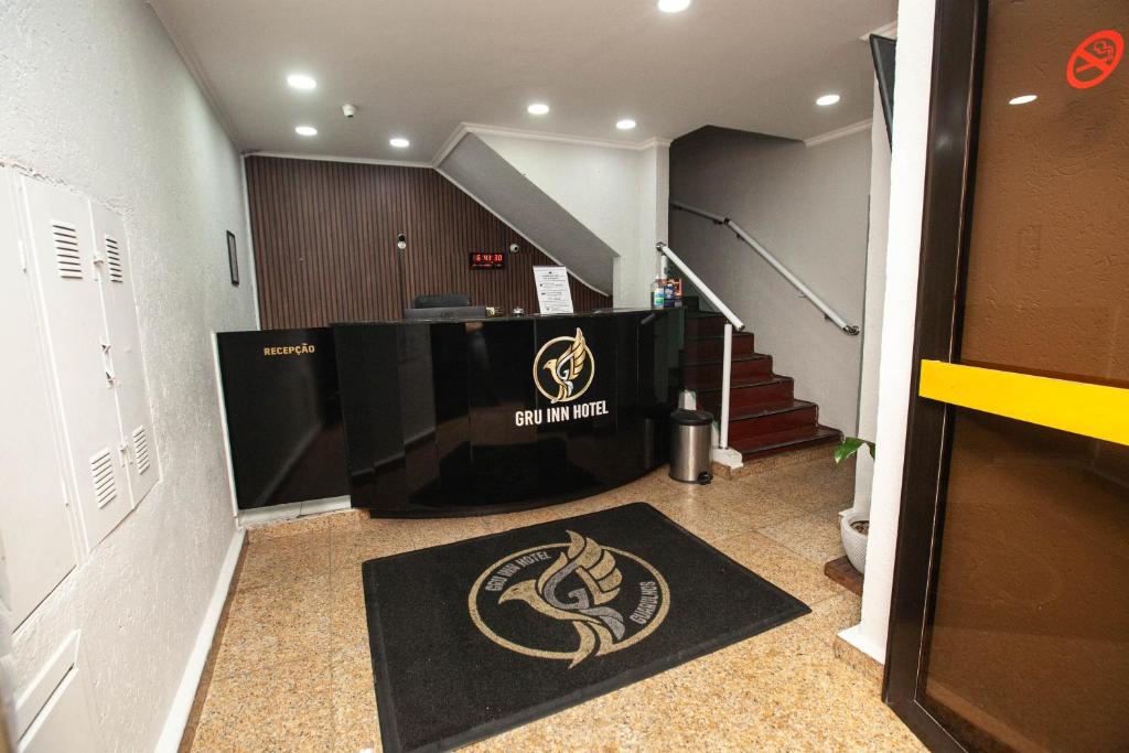 a room with a staircase with a television and a carpet at Gru Inn Hotel in Guarulhos