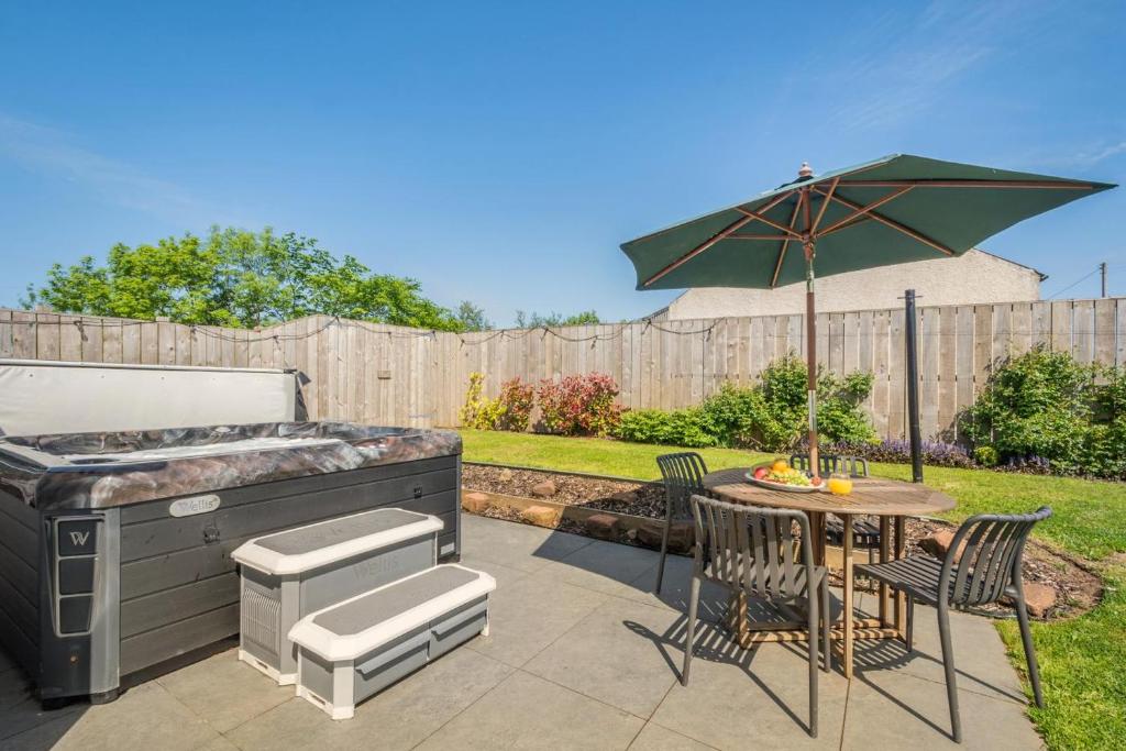 a patio with a grill and a table with at 1 Bed in Stewarton oc-c44699 in Stewarton