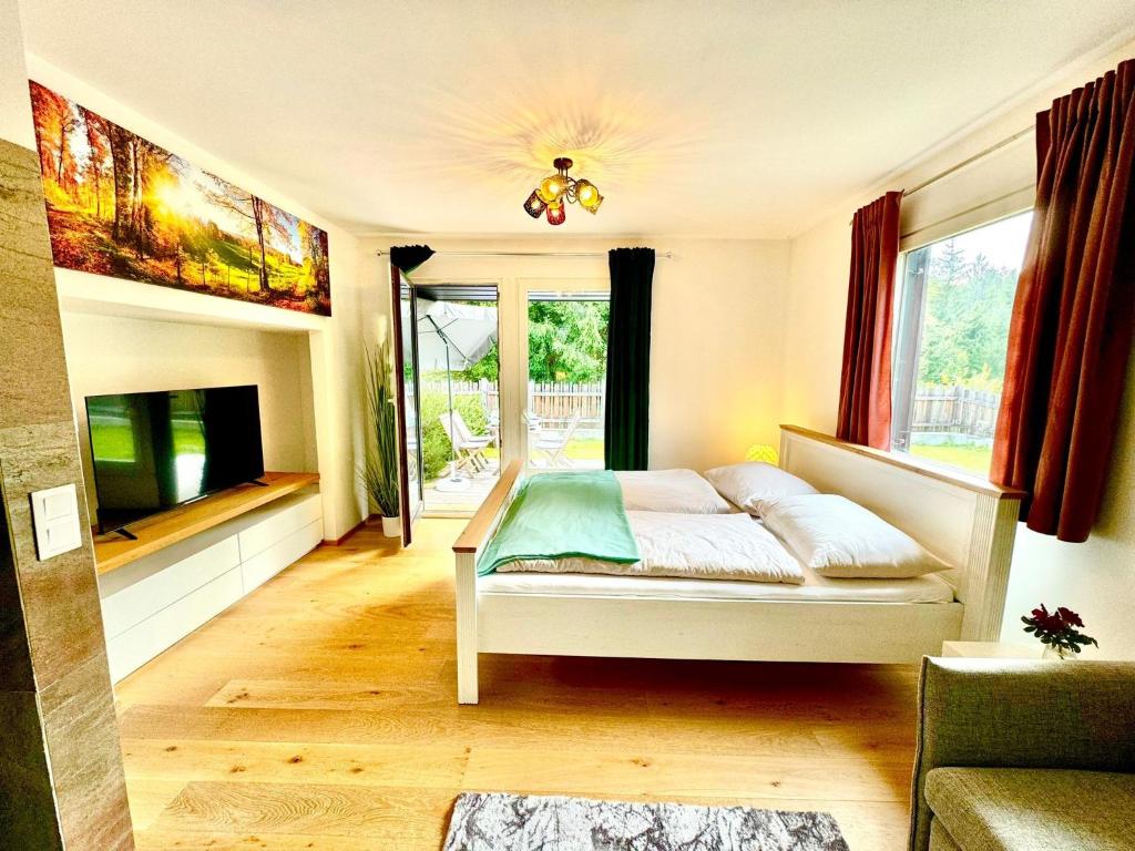 a bedroom with a bed and a flat screen tv at Auszeit im Grünen in Gailitz