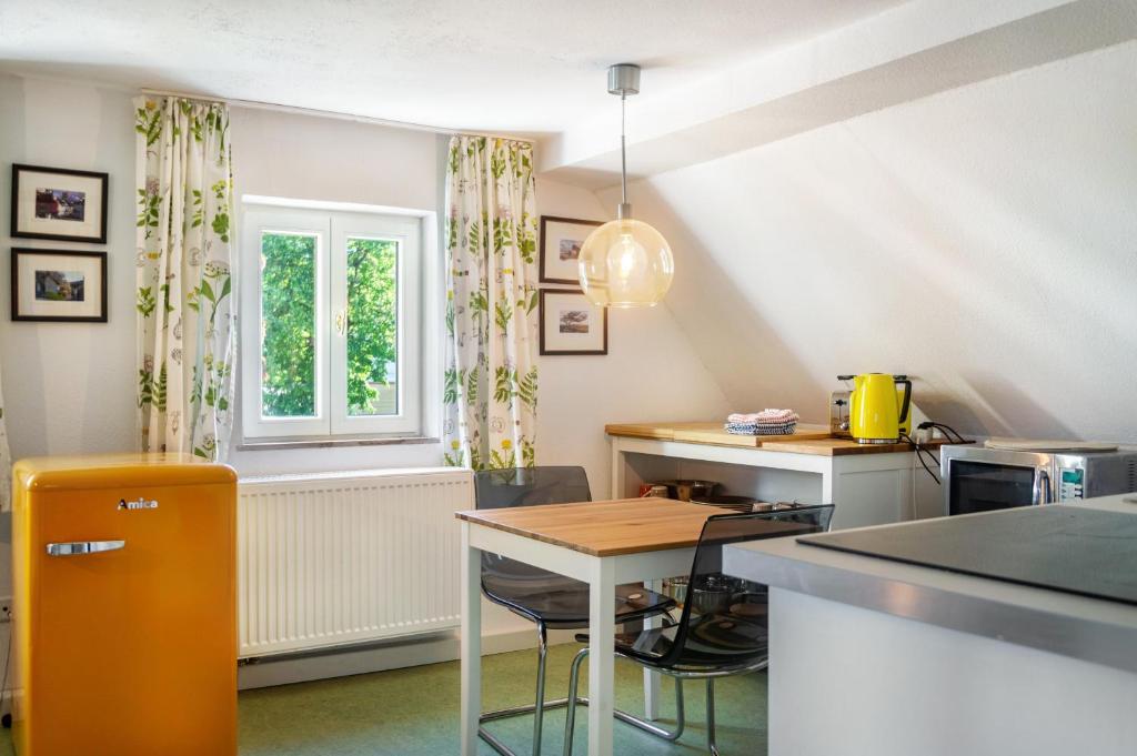 a kitchen with a table and a window at Alte Schmiede Ellrichshausen 2 in Satteldorf