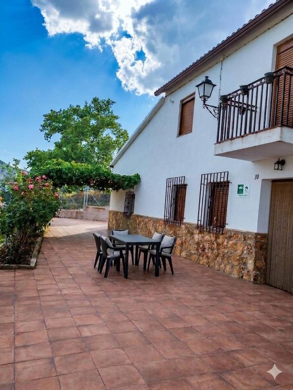 a patio with a table and chairs in front of a building at Casa Arroyo de la Celada in Riópar