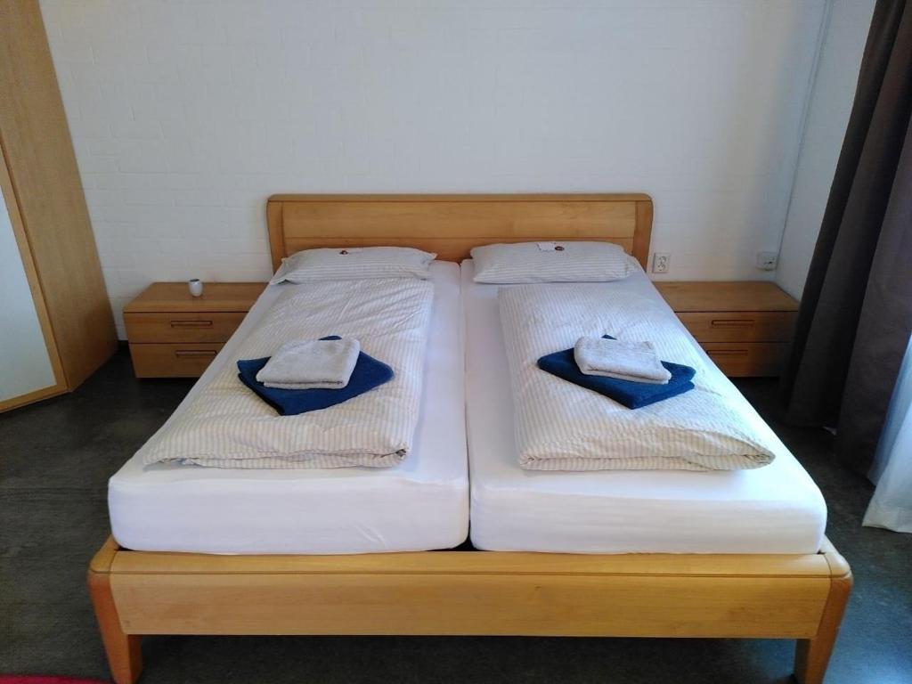 two beds with white sheets and blue towels on them at Gästewohnung am Sternberg in Gomadingen