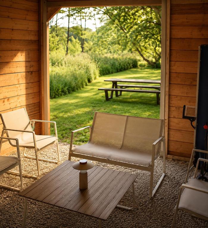 a porch with two chairs and a table and a picnic table at B&B The Parklane Retreat in Schoten