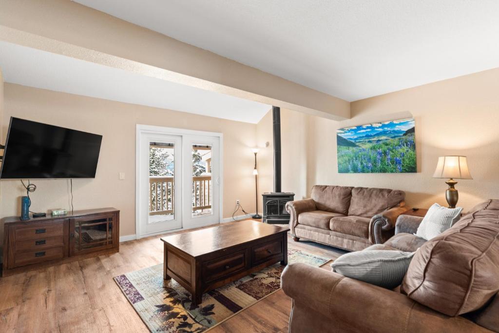 a living room with two couches and a flat screen tv at Rockridge #51 in Breckenridge