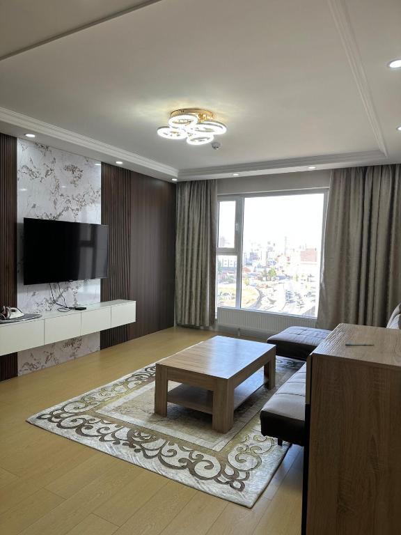 a living room with a table and a tv at Newly built Modern 2 BR apartment in Ulaanbaatar