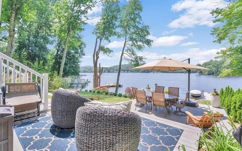 a patio with chairs and an umbrella next to the water at Lakeside Haven, Tranquil Waters in Holland