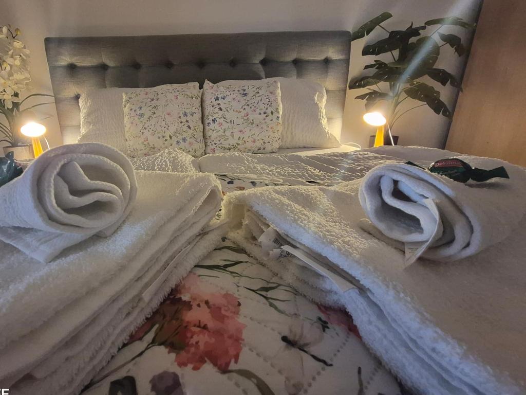a bed with white sheets and towels on it at Zafir Luxory in Kaposvár