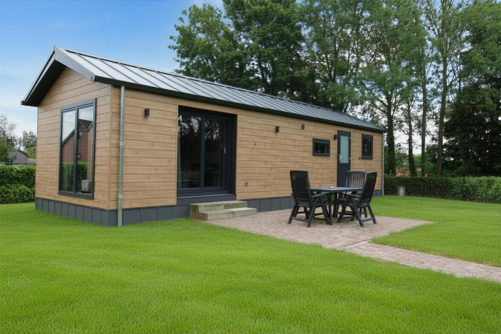 a small cabin with a table and chairs in a yard at Nieuw!! Chalet De Luxe 4 persoons met airco in Oorsbeek