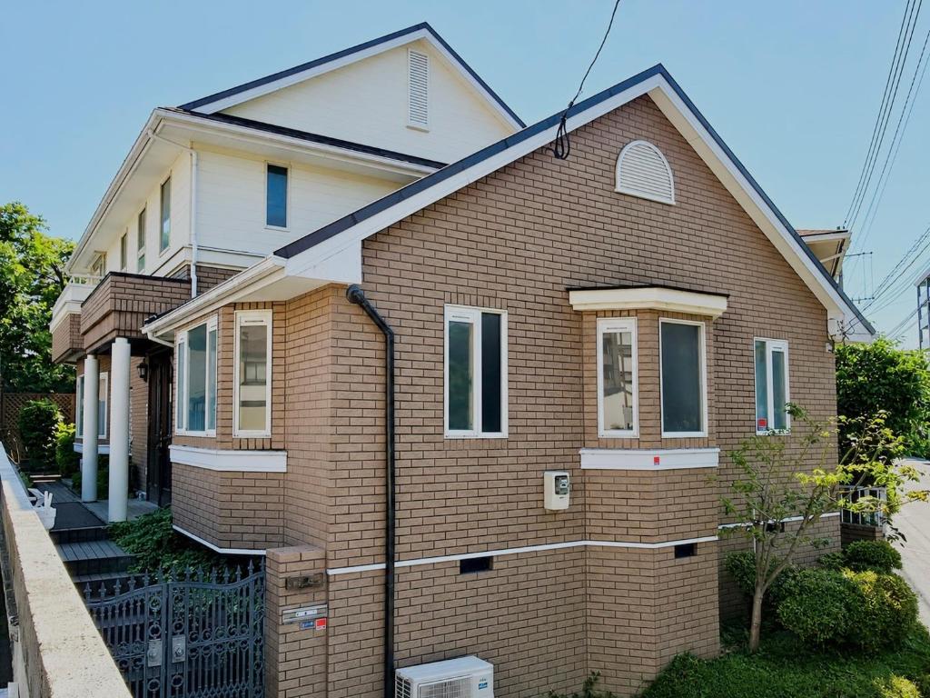a brown brick house with a white at 禮 -Rei House- in Muromimachi
