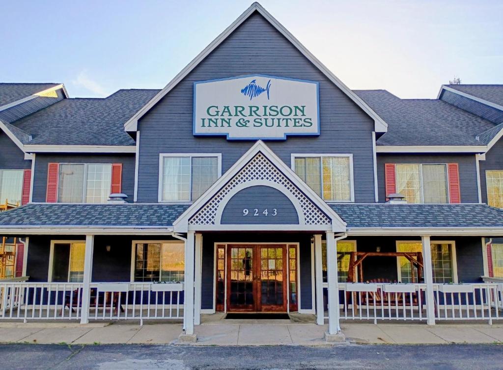 a building with a sign that reads gardeninson inn and suites at Garrison Inn and Suites in Garrison