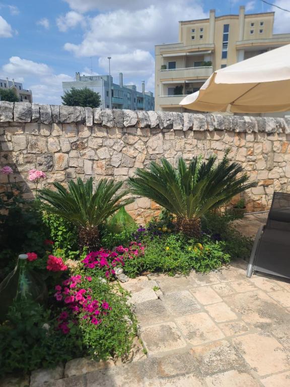 a stone retaining wall with flowers and plants at Casa Nonna Renzina in Locorotondo