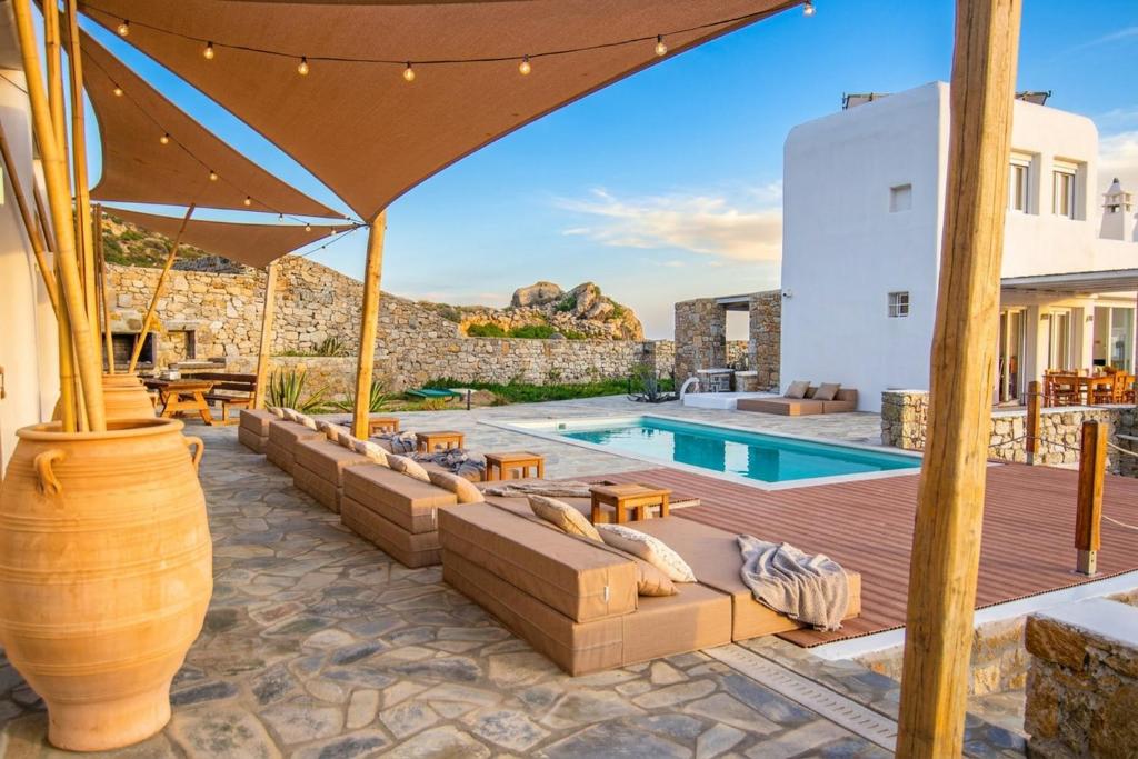 a villa with a swimming pool and a patio at Villa Poppy Mykonos in Mikonos