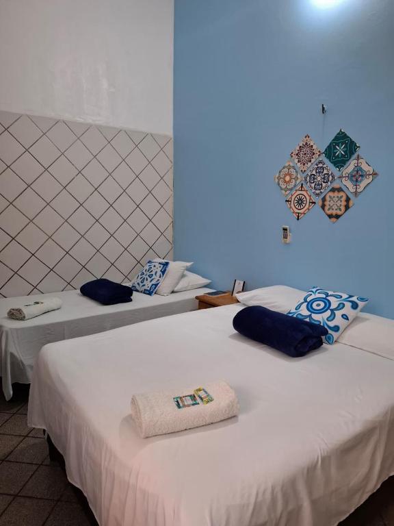 zwei Betten in einem Zimmer mit blauem Licht in der Unterkunft Hotel Ilha dos Azulejos in São Luís