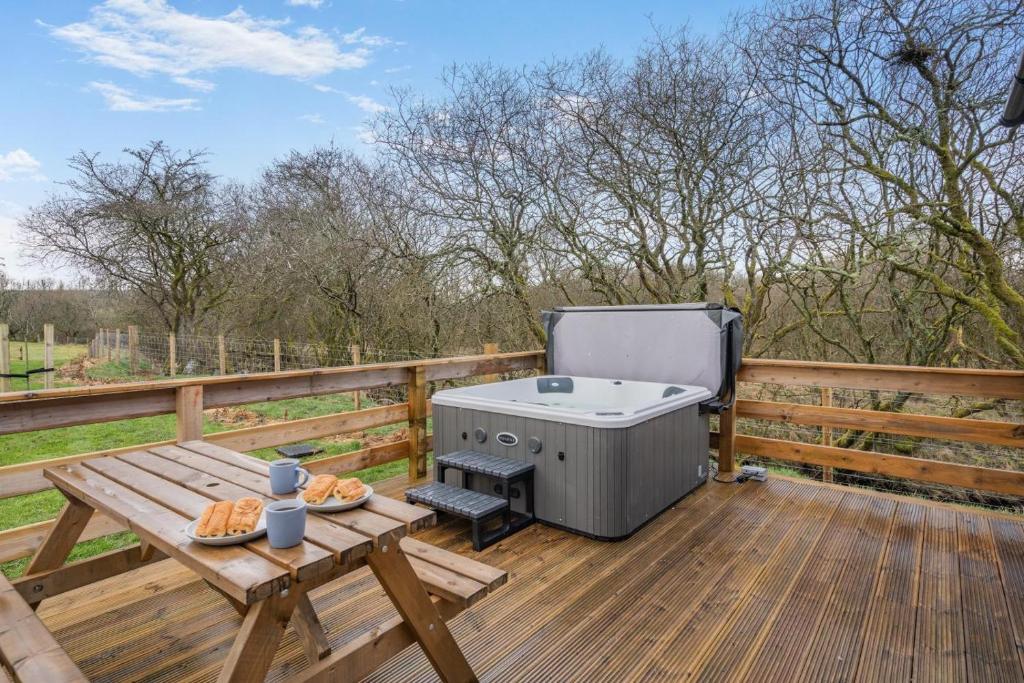 a barbecue on a wooden deck with a picnic table at 2 Bed in Ochiltree oc-w37516 in Ochiltree