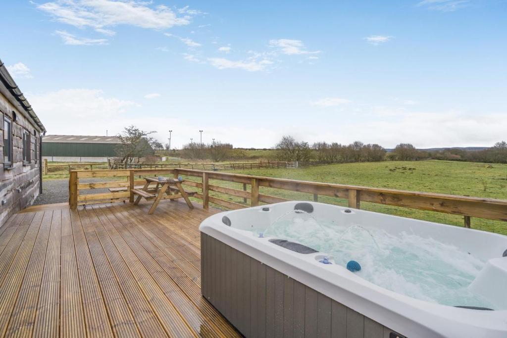 a hot tub on a deck with a view of a field at 2 Bed in Ochiltree oc-w37517 in Ochiltree
