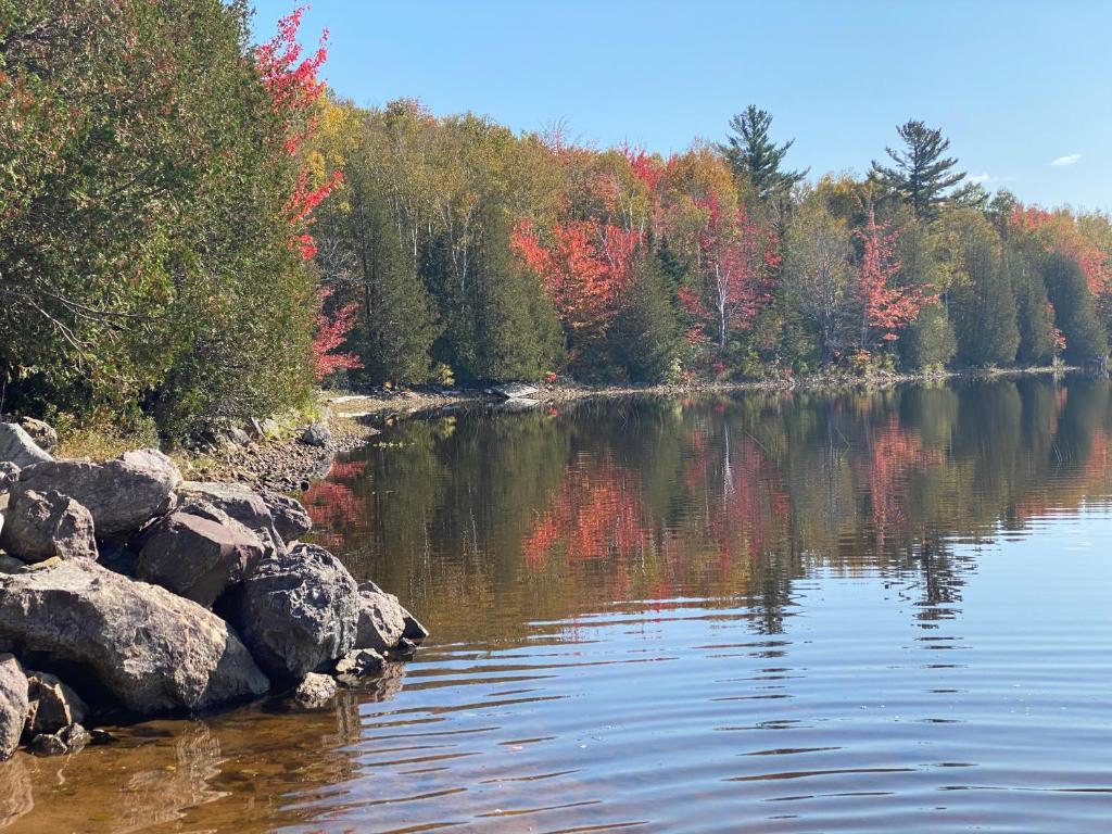 a body of water with colorful trees in the background at Oak Glade RV site in Westfield Beach