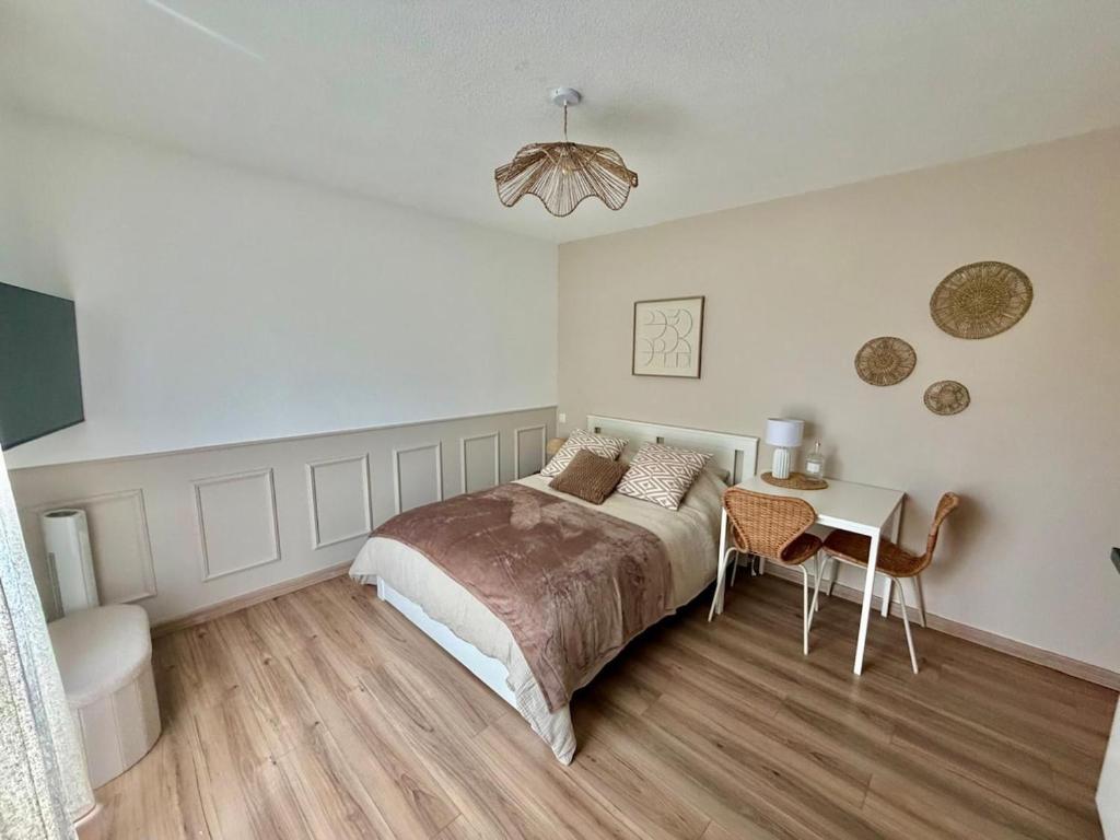 a bedroom with a bed and a table in it at Numéro 6 in Toulouse