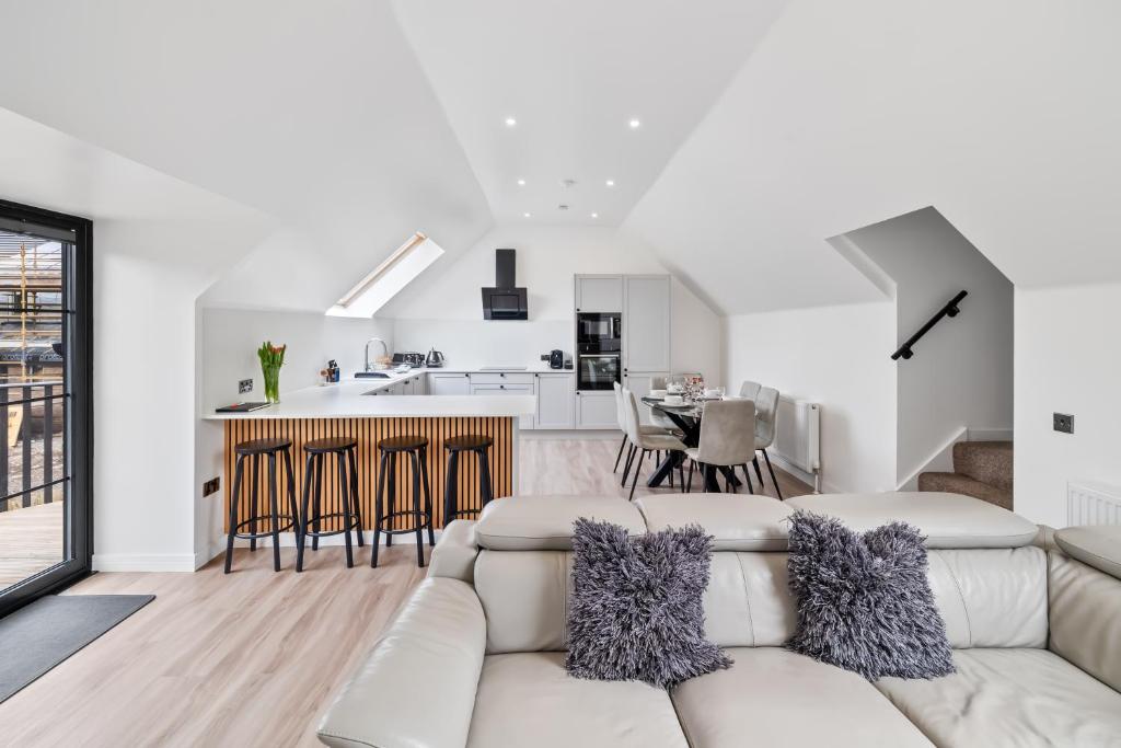 a living room with a white couch and a kitchen at Corn Flour Lodge - Pitkerro Mill in Dundee