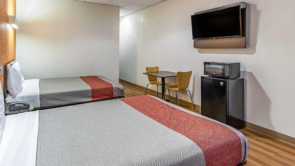 a room with two beds and a flat screen tv at Hotel Elizabeth Near Newark Liberty International Airport New Jersey in Elizabeth
